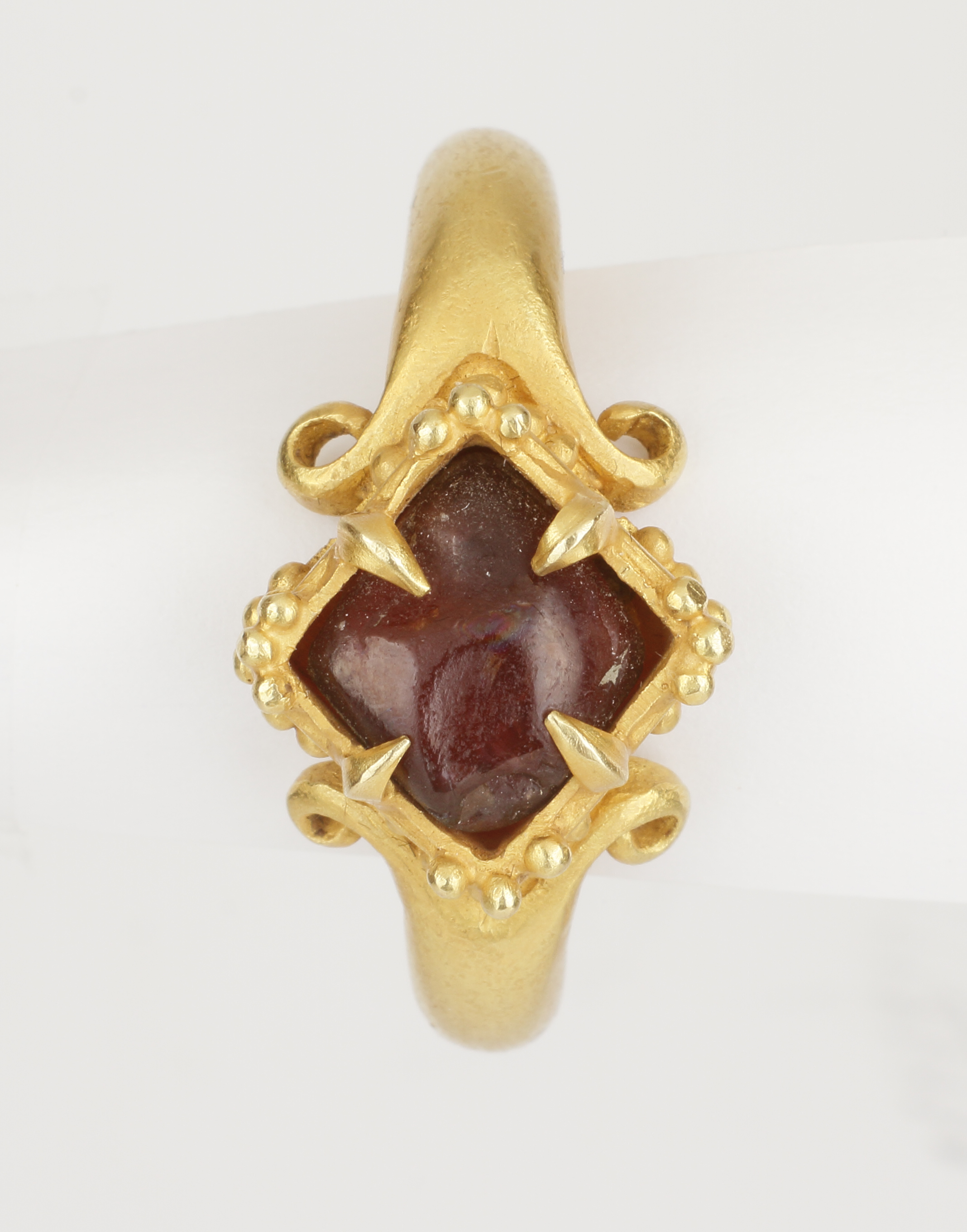 A Fine Temple Ring Set with a Rough Garnet and Raised, Lobed Bezel